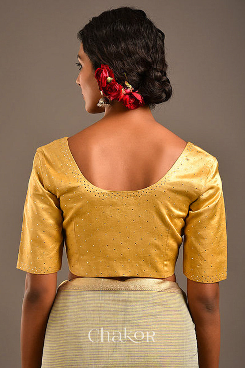 Woman wearing a handcrafted gold Mashru Silk Blouse with mukaish embroidery.