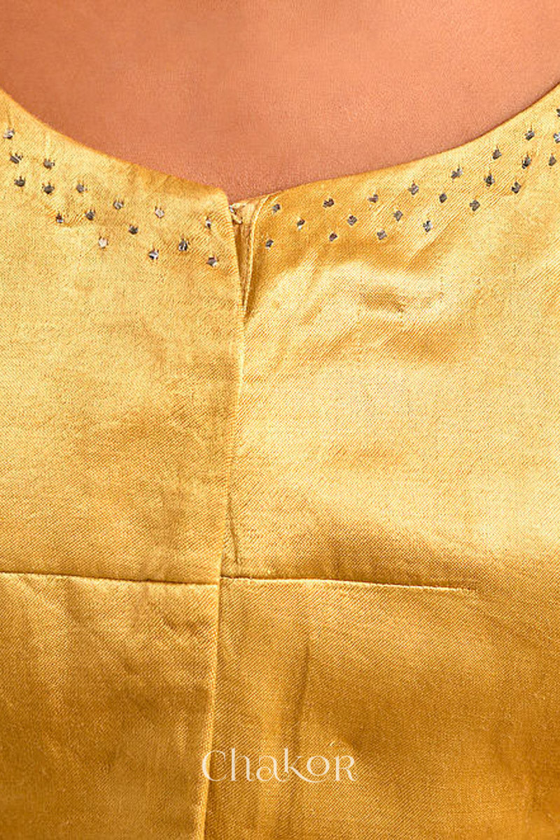Woman wearing a handcrafted gold Mashru Silk Blouse with mukaish embroidery.