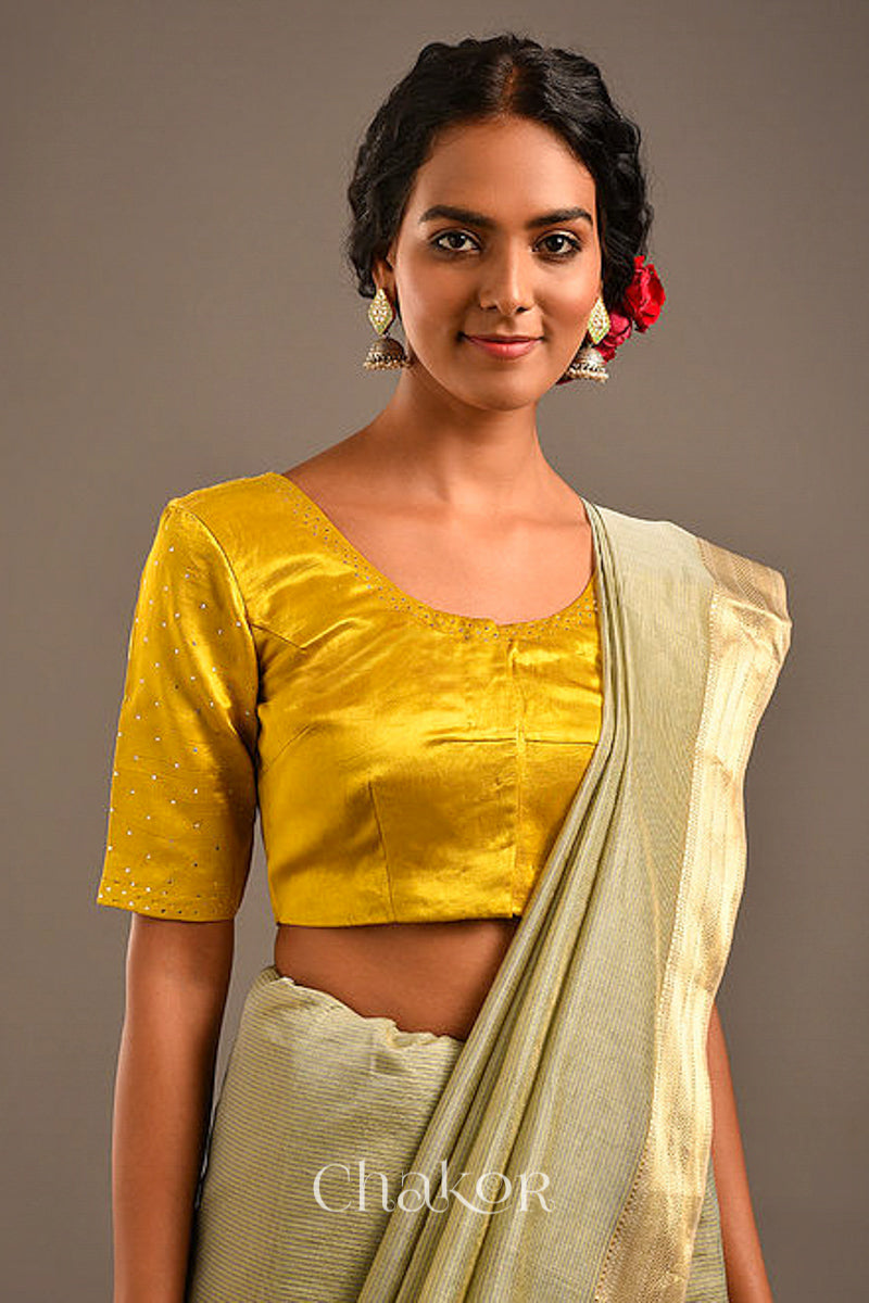Woman wearing handcrafted Mustard Mashru Silk Blouse with mukaish embroidery. 