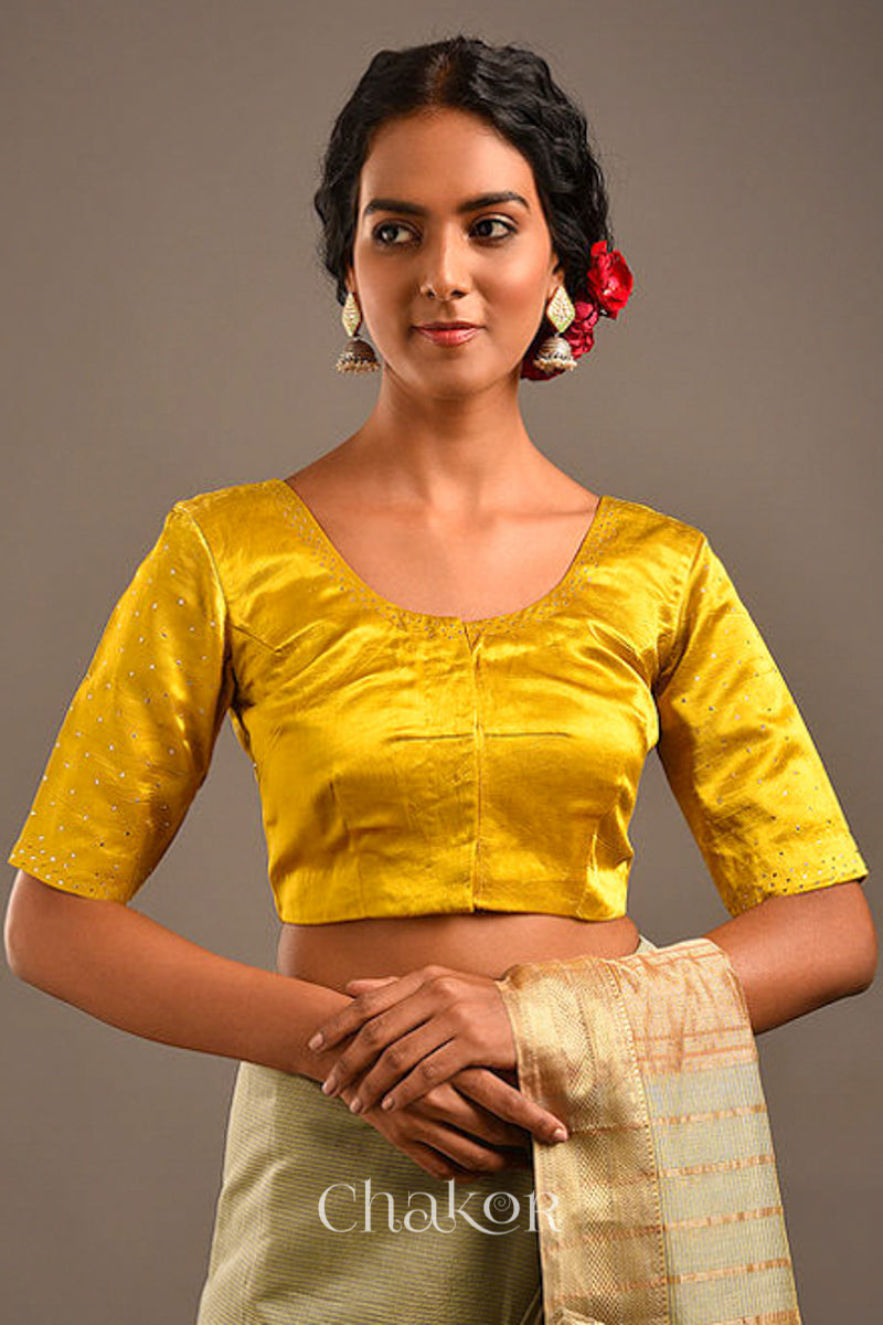 Woman wearing handcrafted Mustard Mashru Silk Blouse with mukaish embroidery.