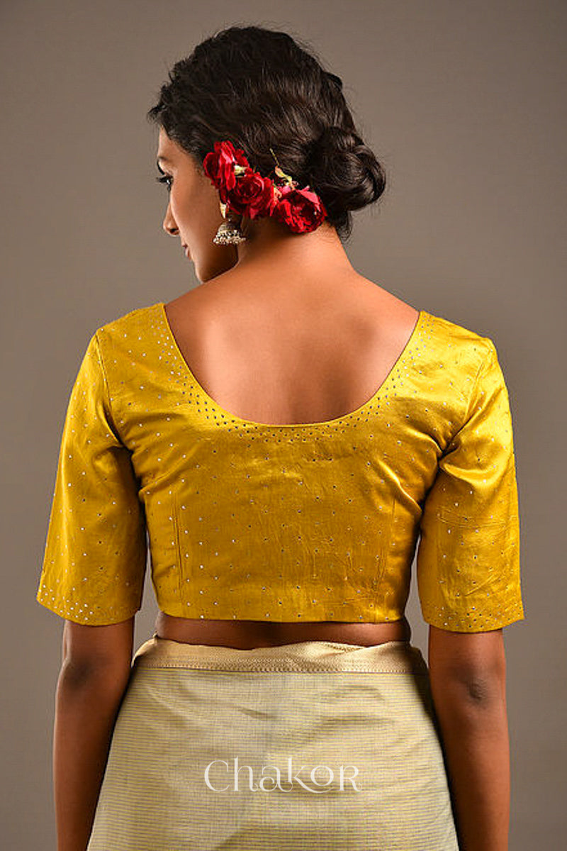 Woman wearing handcrafted Mustard Mashru Silk Blouse with mukaish embroidery.