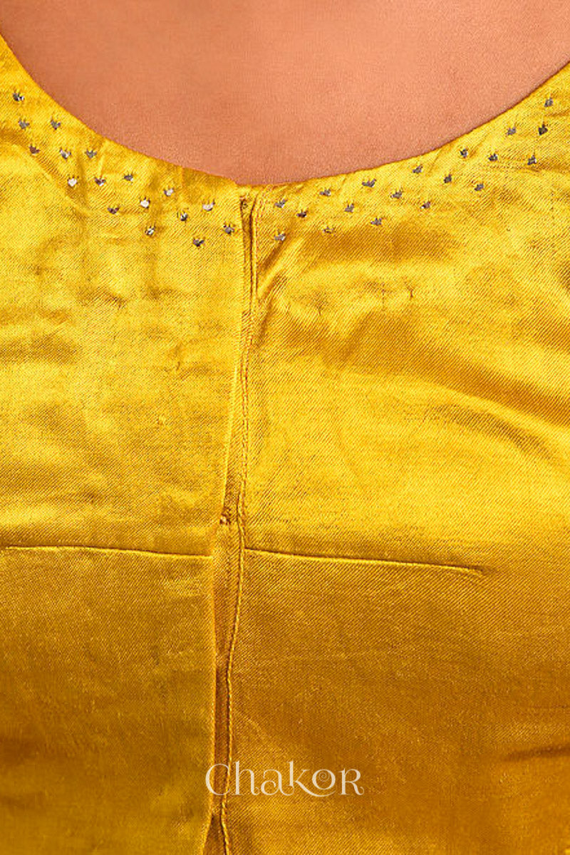Woman wearing handcrafted Mustard Mashru Silk Blouse with mukaish embroidery.