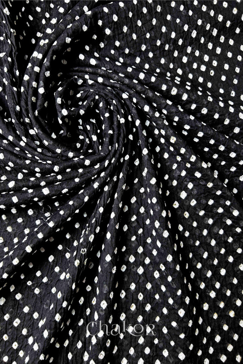 Detail view of Black Bandhani mul cotton dupatta highlighting tie-dye dots arranged in spiral drape.