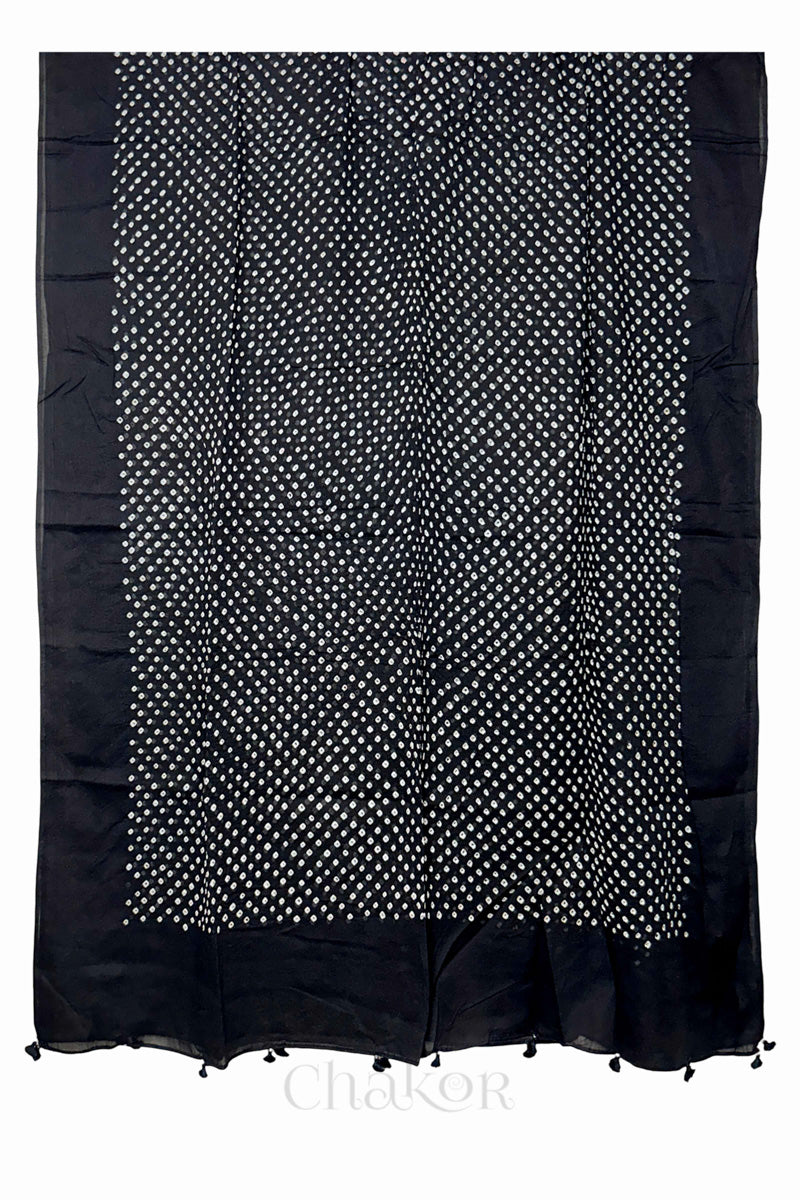 Full-length flat view of Black Bandhani mul cotton dupatta with all-over tie-dye pattern and tassels.