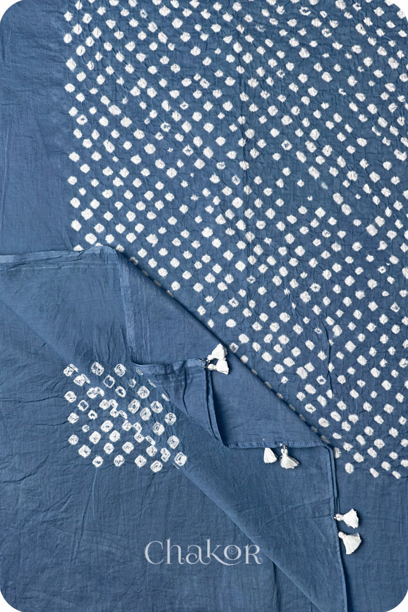 Chakor's blue grey cotton dupatta adorned with white bandhej patterns, featuring decorative tassels at the edges, showcasing intricate craftsmanship.
