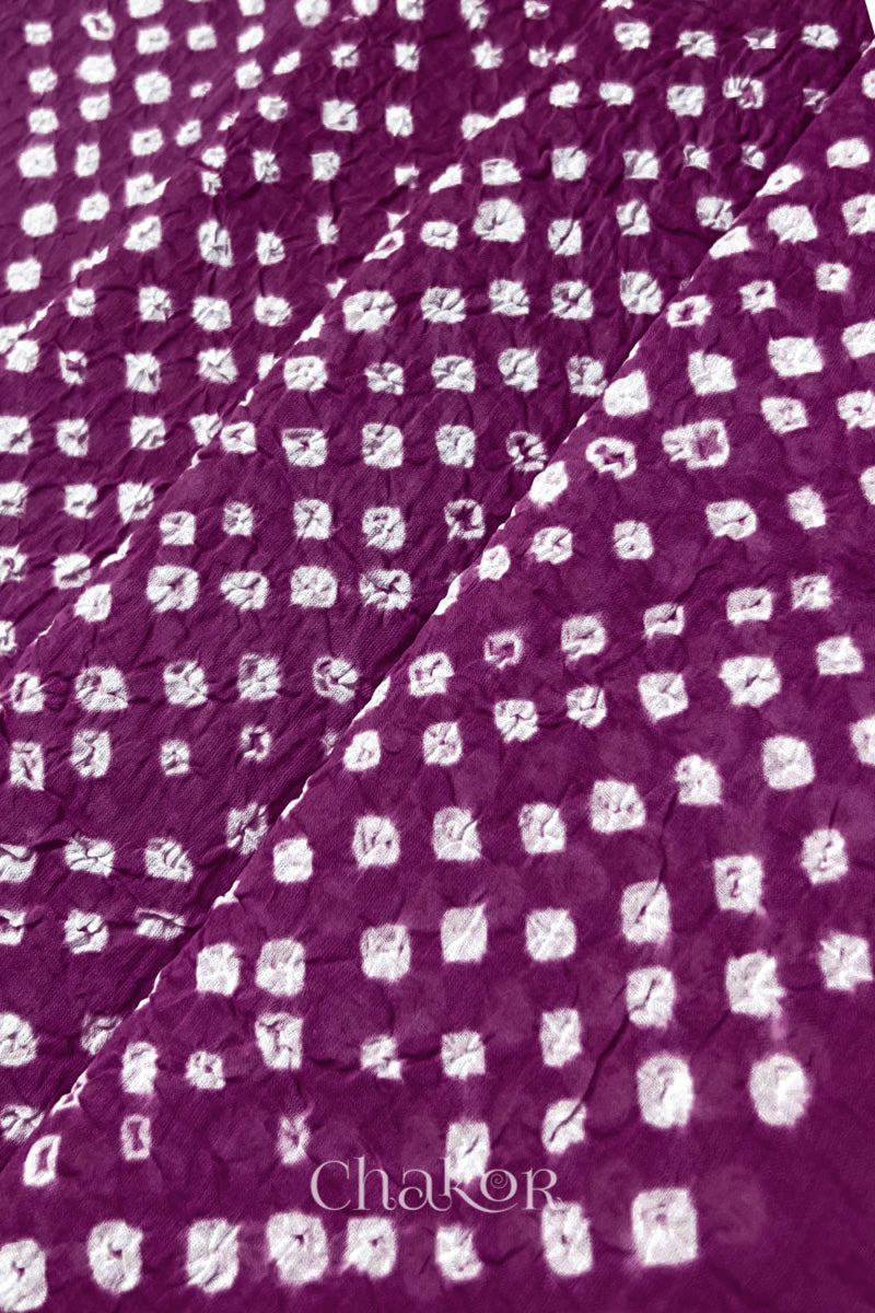 Close-up of magenta Bandhani tie-dye dot pattern on mul cotton dupatta fabric.
