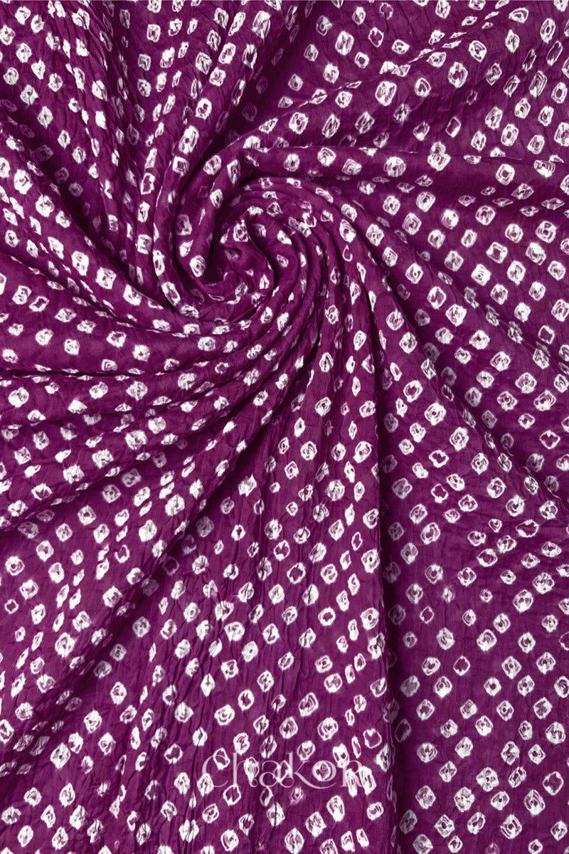 Twisted detail view of magenta Bandhani mul cotton dupatta highlighting tie-dye dots.
