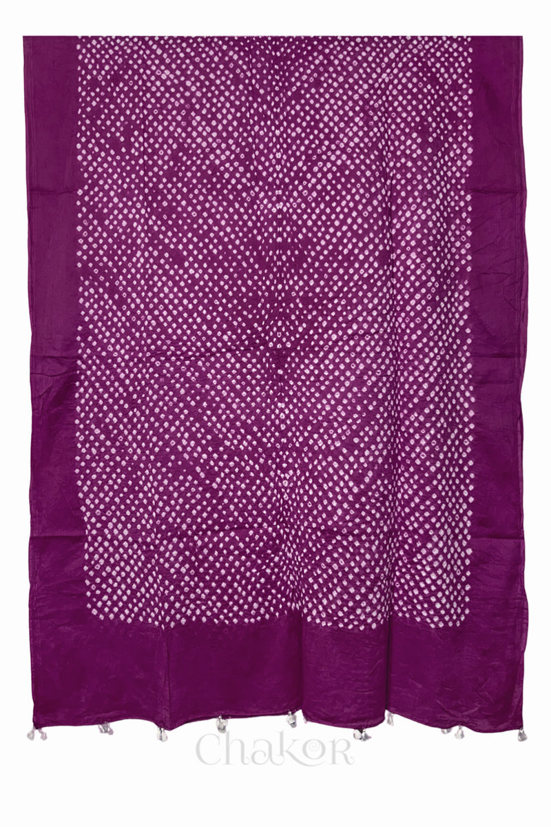 Full-length flat view of magenta Bandhani mul cotton dupatta with all-over tie-dye pattern and tassels.