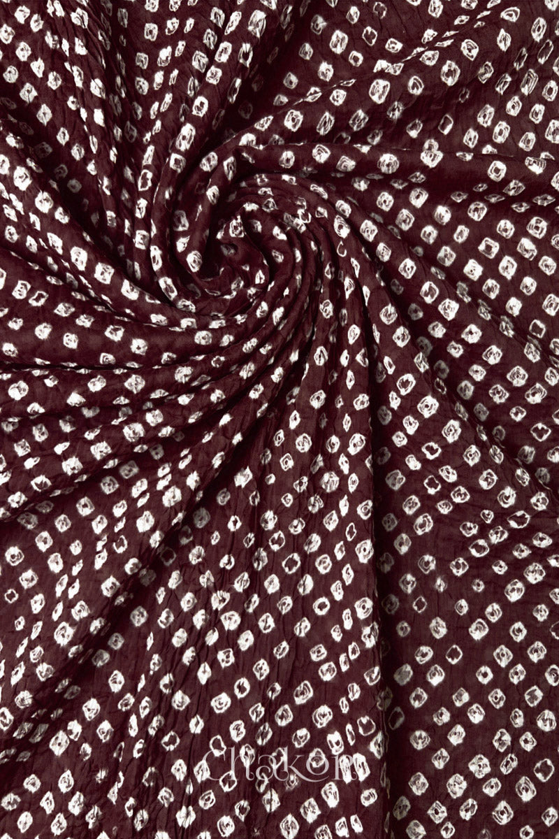 Detail view of Dark maroon Bandhani mul cotton dupatta highlighting tie-dye dots arranged in spiral drape.
