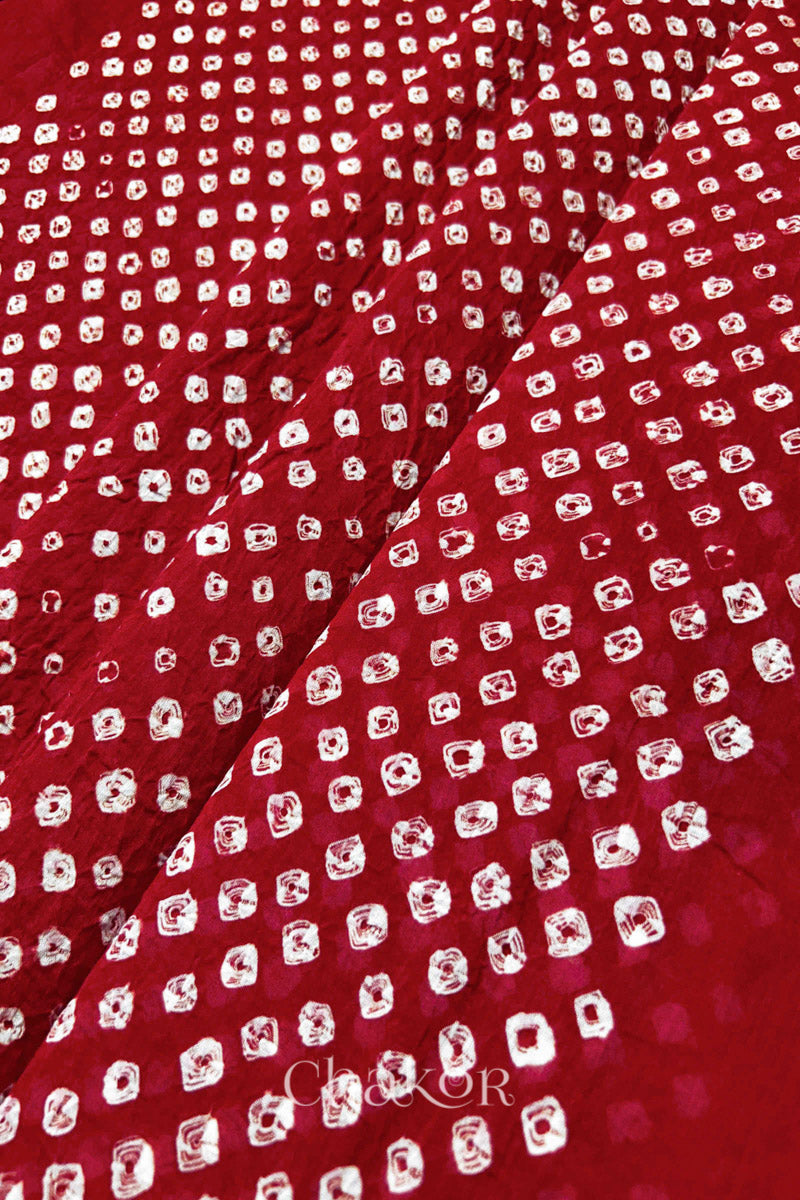 Close-up of Tomato Red Bandhani tie-dye dot pattern on mul cotton dupatta fabric.