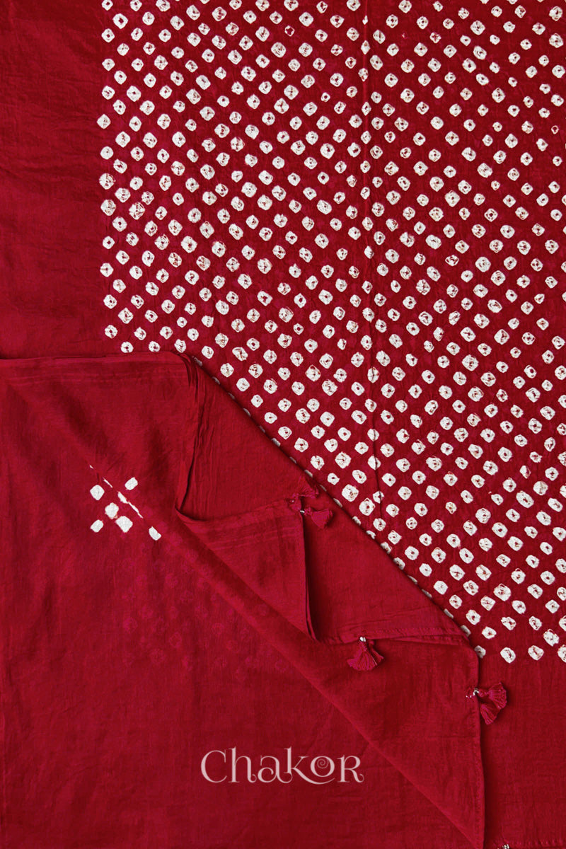 Corner detail of Tomato Red Bandhani mul cotton dupatta showing pallu tasseled edge and tie-dye motifs.