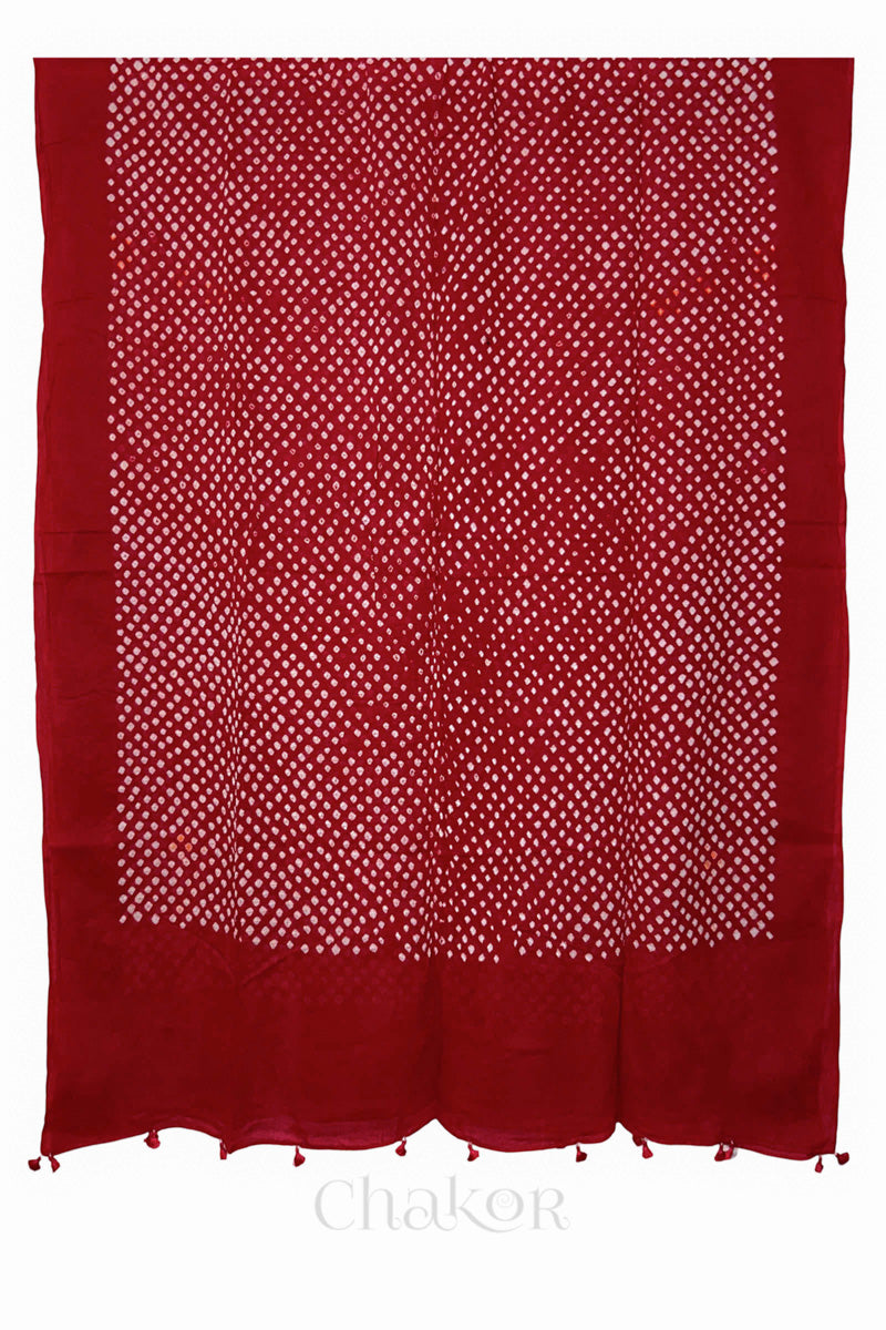 Full-length flat view of Tomato Red Bandhani mul cotton dupatta with all-over tie-dye pattern and tassels.