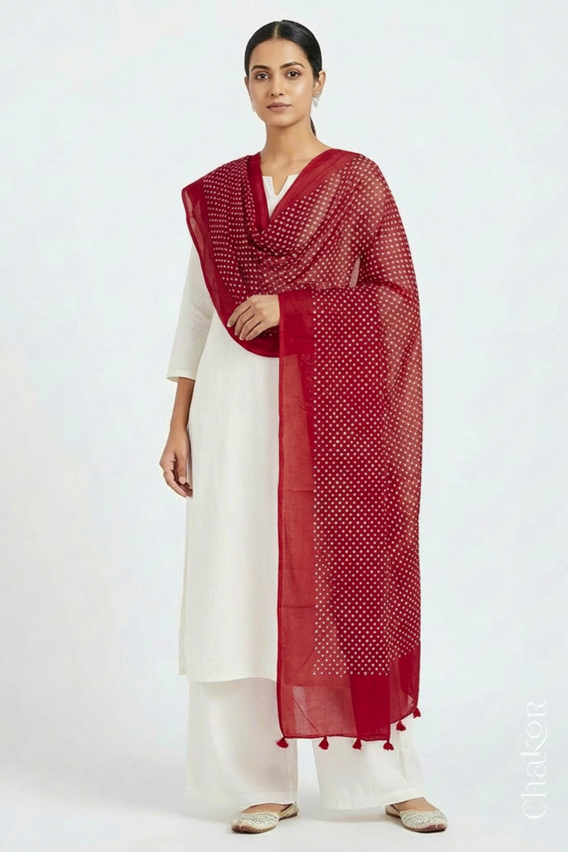 Model wearing Tomato Red Bandhani mul cotton dupatta with tie-dye dot pattern draped over a white kurta.
