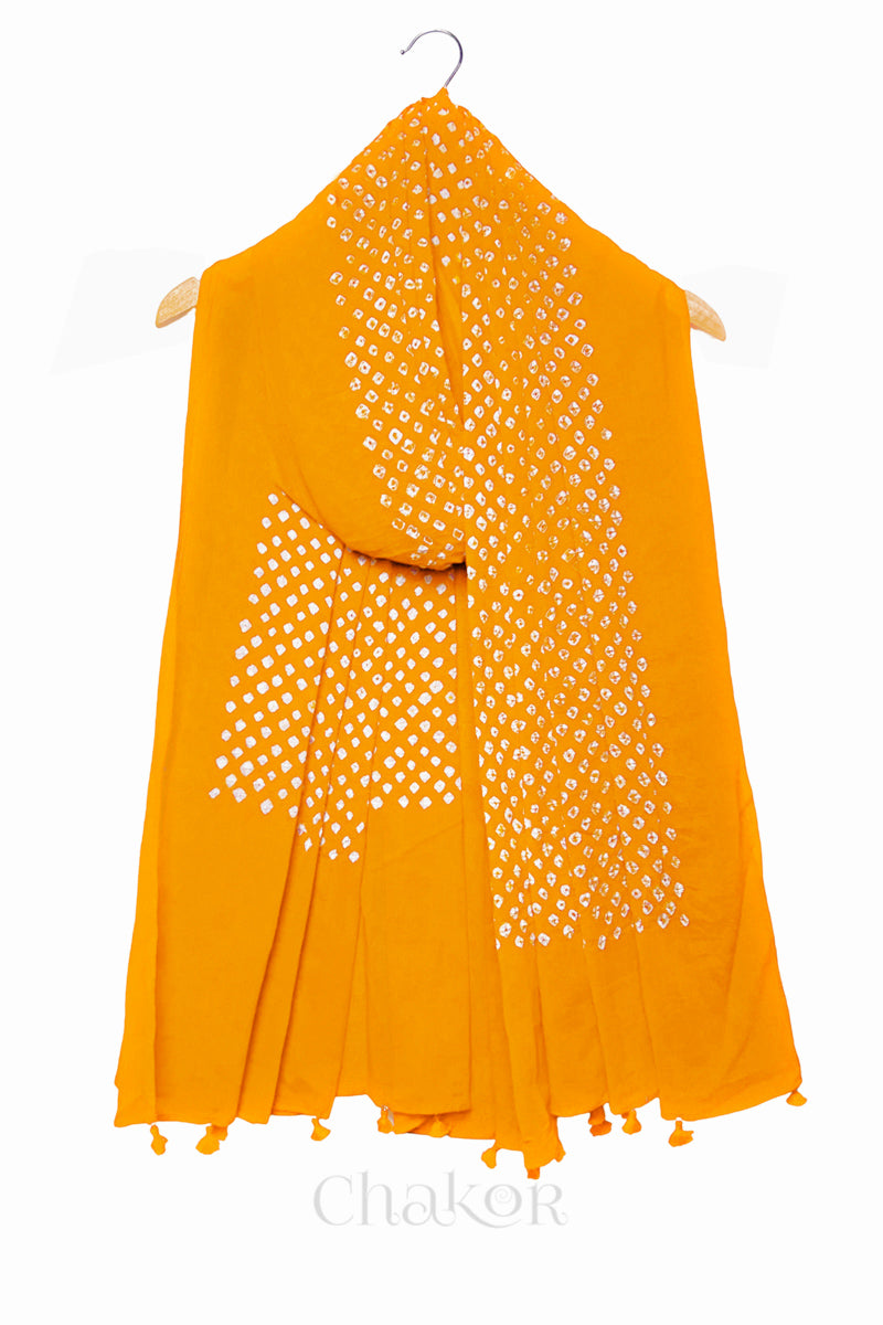 Yellow Bandhani mul cotton dupatta draped on hanger showing tie-dye dot pattern and tasselled edge.