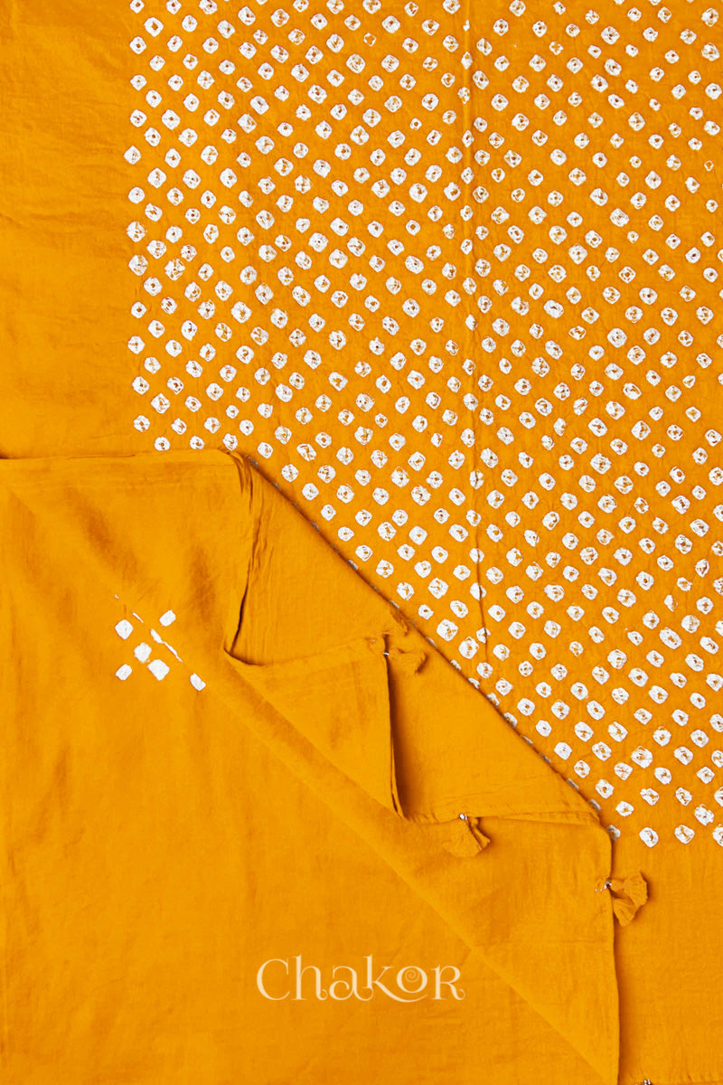 Corner detail of Yellow Bandhani mul cotton dupatta showing pallu tasseled edge and tie-dye motifs.