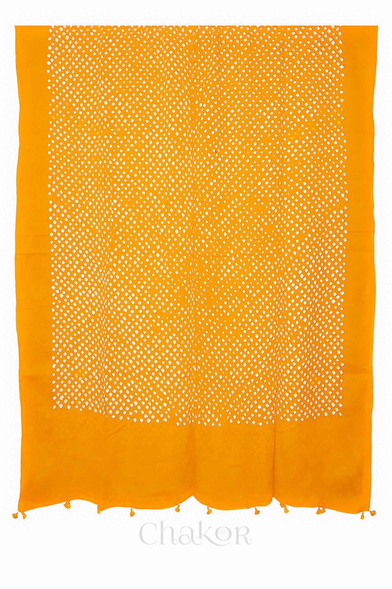 Full-length flat view of Yellow Bandhani mul cotton dupatta with all-over tie-dye pattern and tassels.
