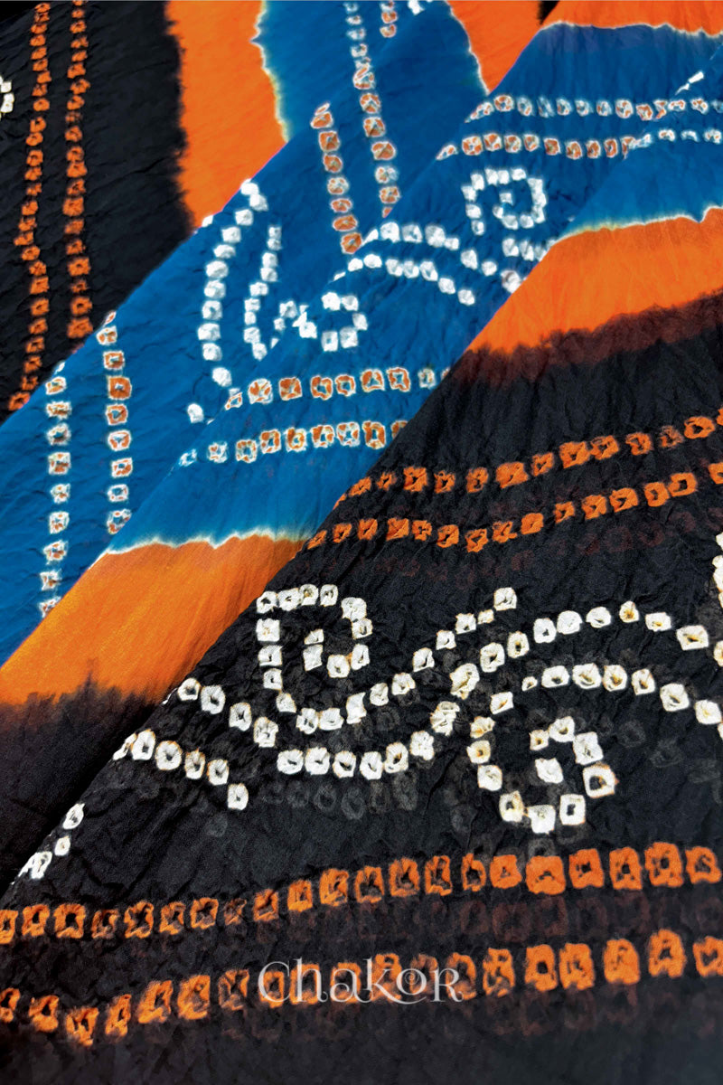 Close-up of indigo and black Bandhani mul cotton dupatta showing tie-dye dots and diagonal colour bands.