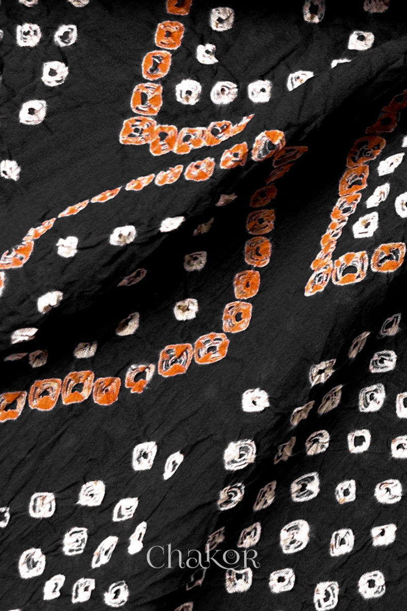 Close-up of hand tied Bandhani dots on Black mulmul cotton fabric.
