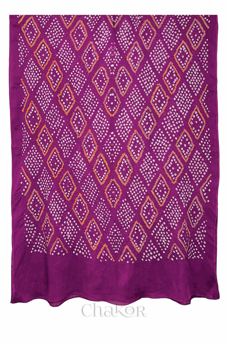 Close-up of hand tied Bandhani dots on Magenta mulmul cotton fabric.
