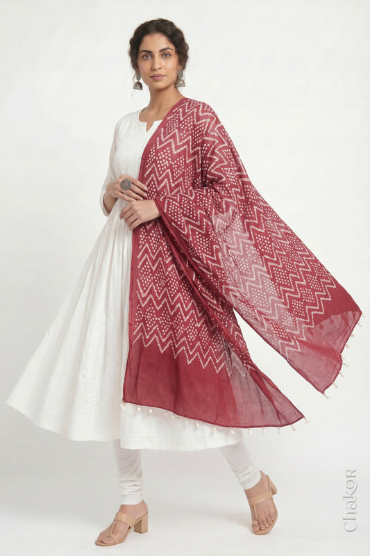 Dusty red Kutch Bandhani dupatta in mercerised mulmul cotton shown in side drape styling.
