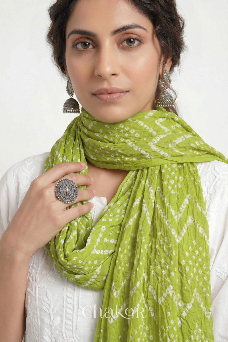 Lime Green Kutch Bandhani mulmul dupatta wrapped around woman's neck.
