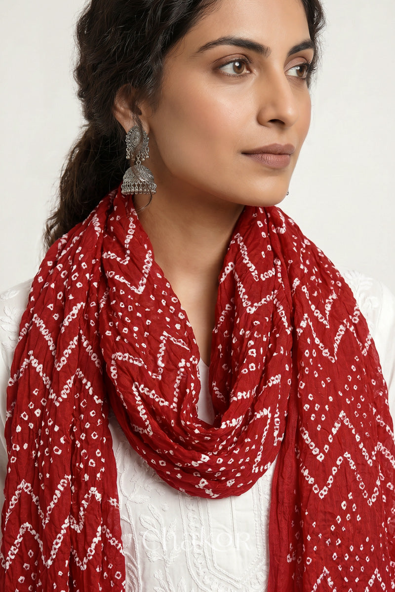 Red Kutch Bandhani mulmul dupatta wrapped around woman's neck.
