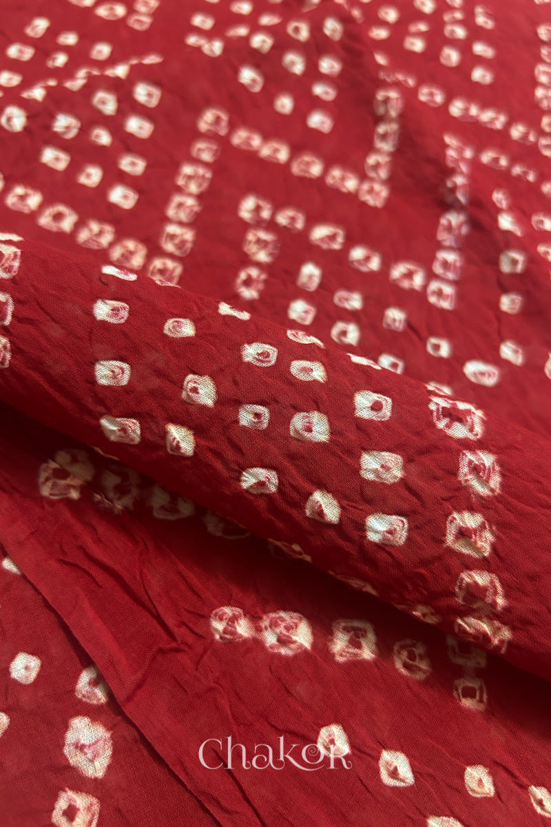 Close up of Traditional hand tied Bandhani pattern on Red mulmul cotton dupatta.
