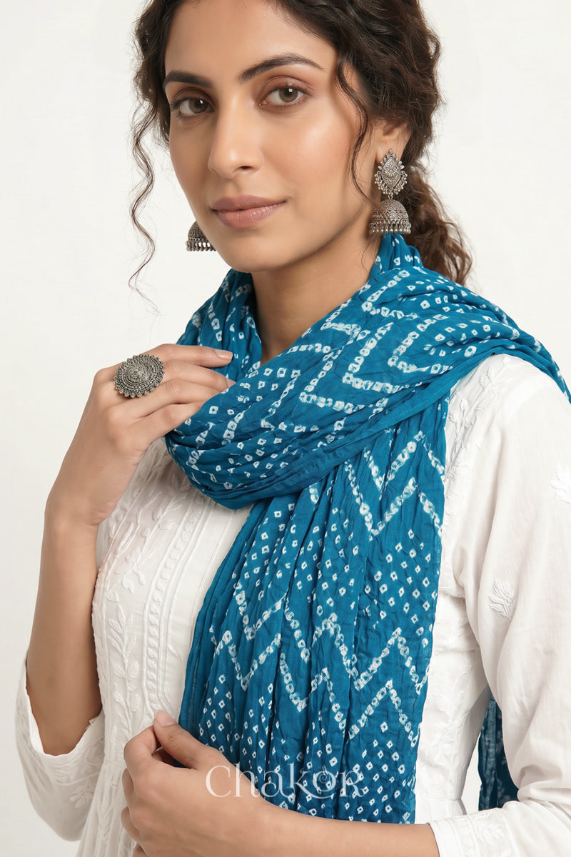 Turquoise Blue Kutch Bandhani mulmul dupatta wrapped around woman's neck.
