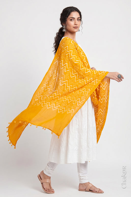 Yellow Kutch Bandhani dupatta in mercerised mulmul cotton shown in side drape styling.
