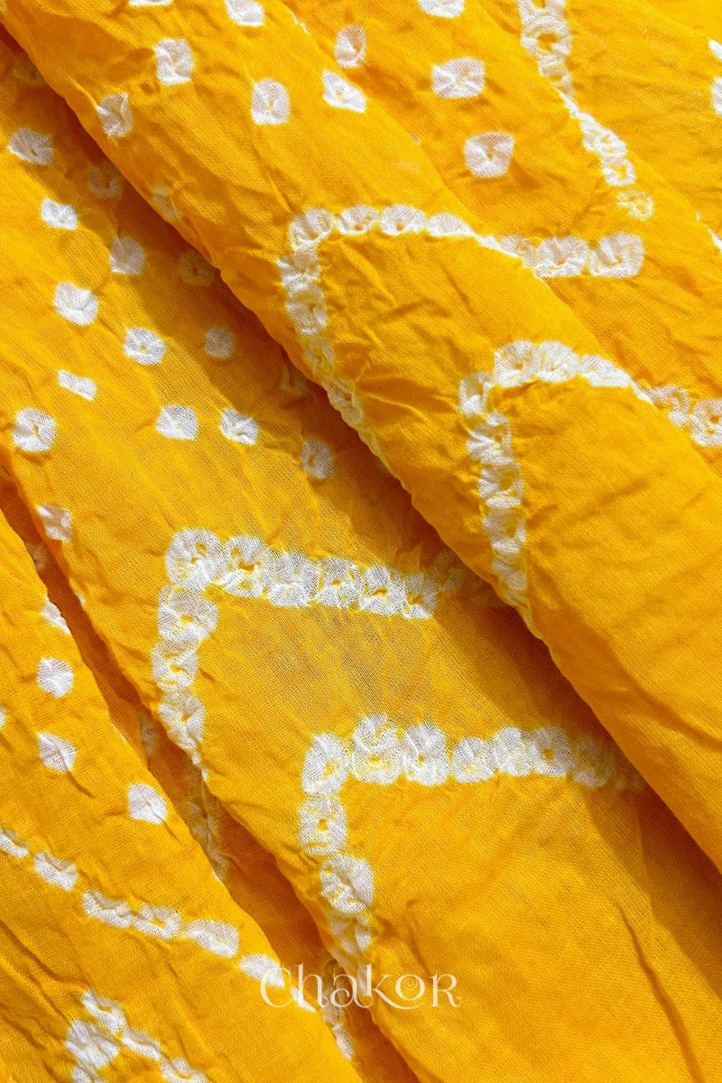 Close up of Traditional hand tied Bandhani pattern on Yellow mulmul cotton dupatta.
