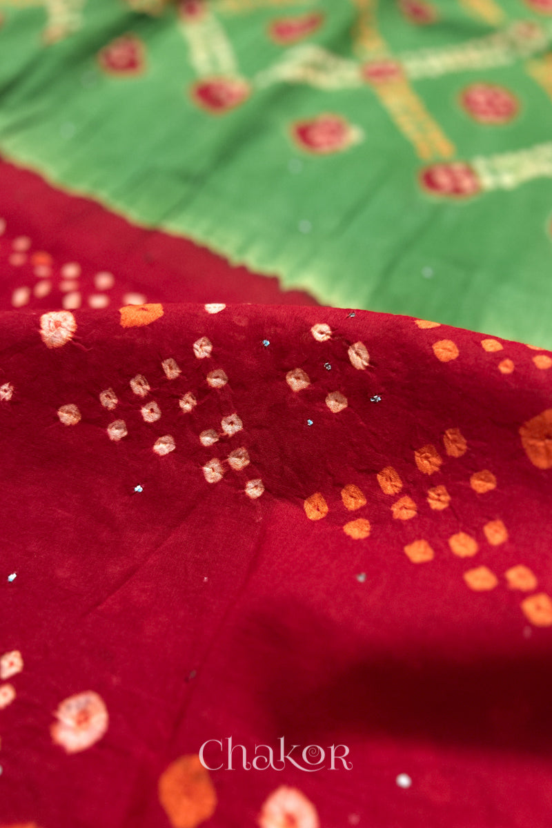 Mulmul cotton bandhani fabric with mukaish embroidery detail in green and red.