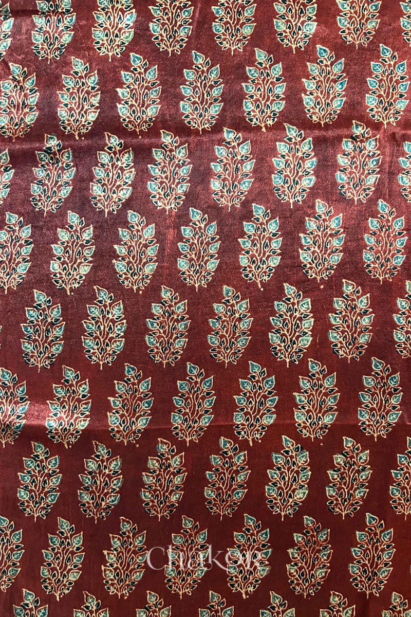 Close up of madder red ajrakh block printed mashru silk kurta fabric.