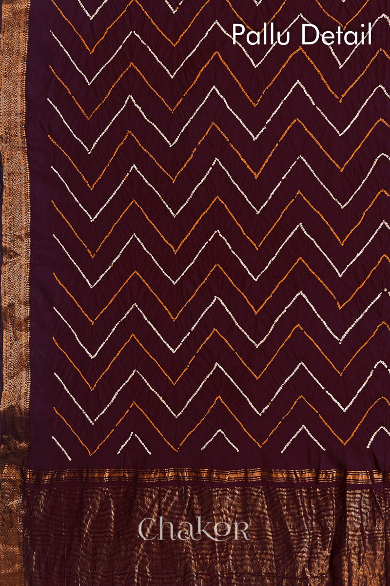 Pallu detail of Maroon bandhani saree with woven golden zari border and pallu.
