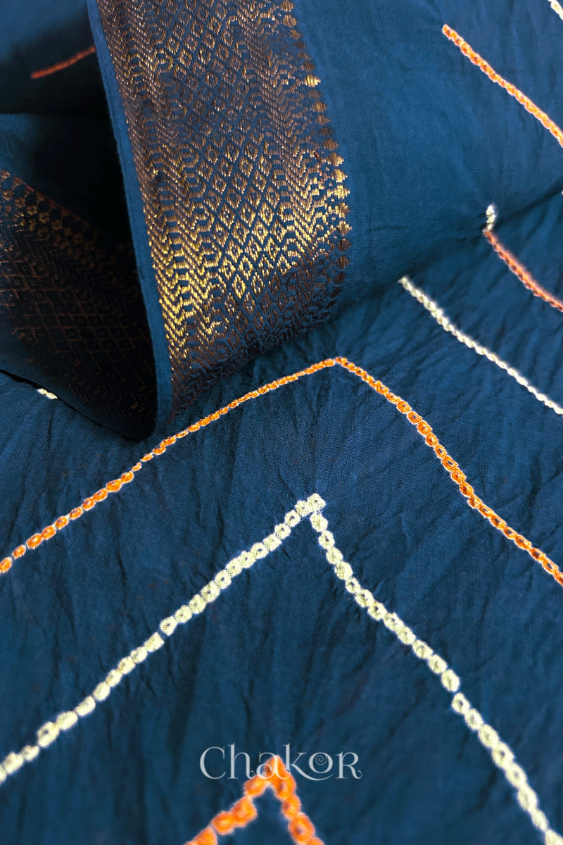 Close-up of indigo blue saree pleats with rai bandhani and zari weaving showcasing beautiful craftsmanship.
