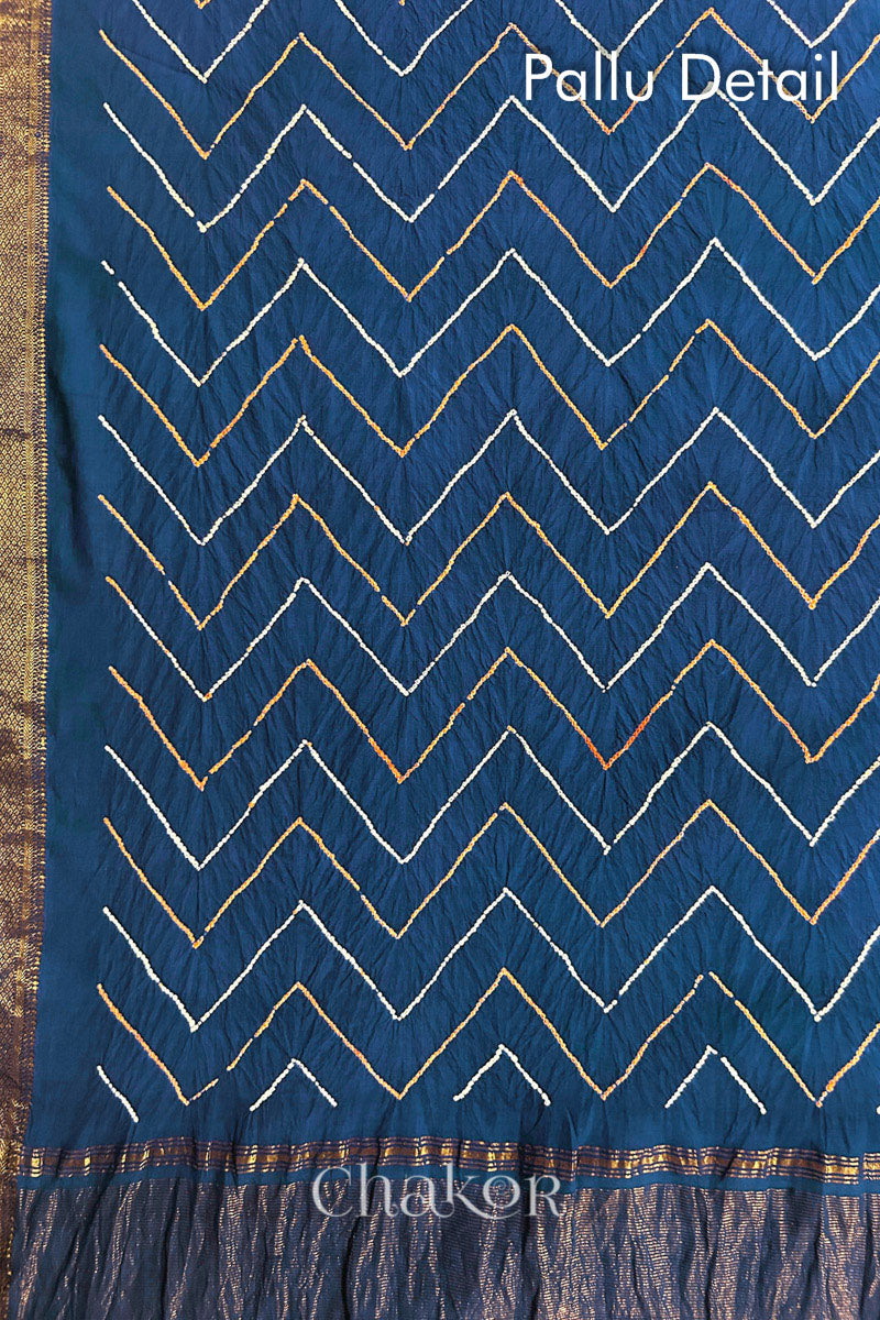 Flat lay of pallu detail of indigo blue bandhani saree with woven golden zari border and pallu.
