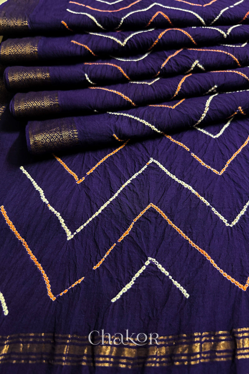 Close-up of Purple saree pleats with rai bandhani and zari weaving showcasing beautiful craftsmanship.
