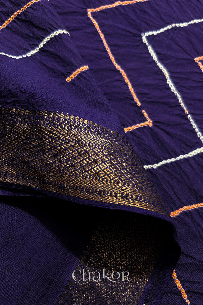 Close-up of Purple sarees featuring rai bandhani and zari weaving showcasing beautiful craftsmanship.
