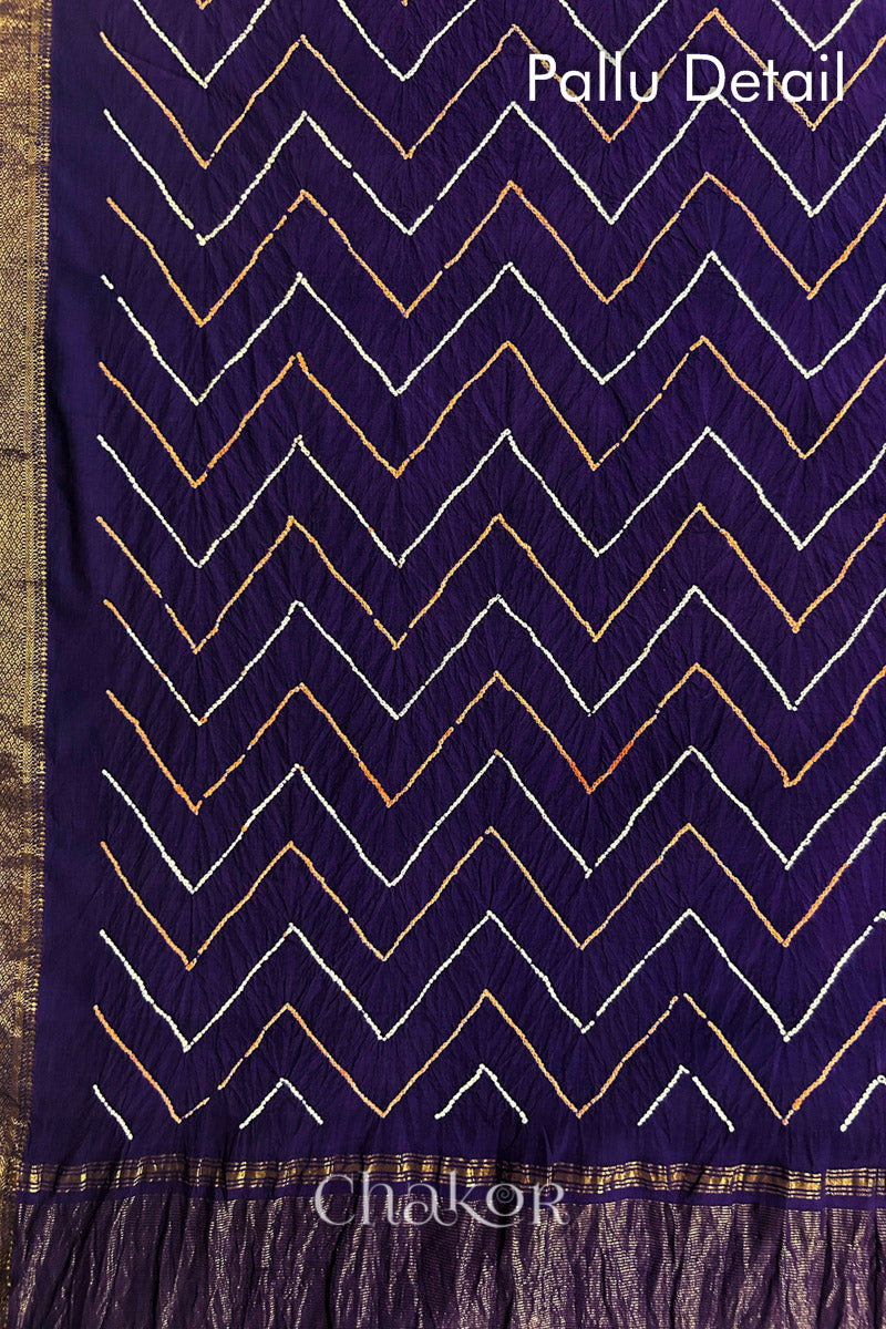 Pallu detail of Purple bandhani saree with woven golden zari border and pallu.
