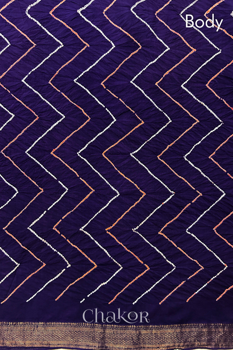 Body detail of Purple bandhani saree with woven golden zari border.