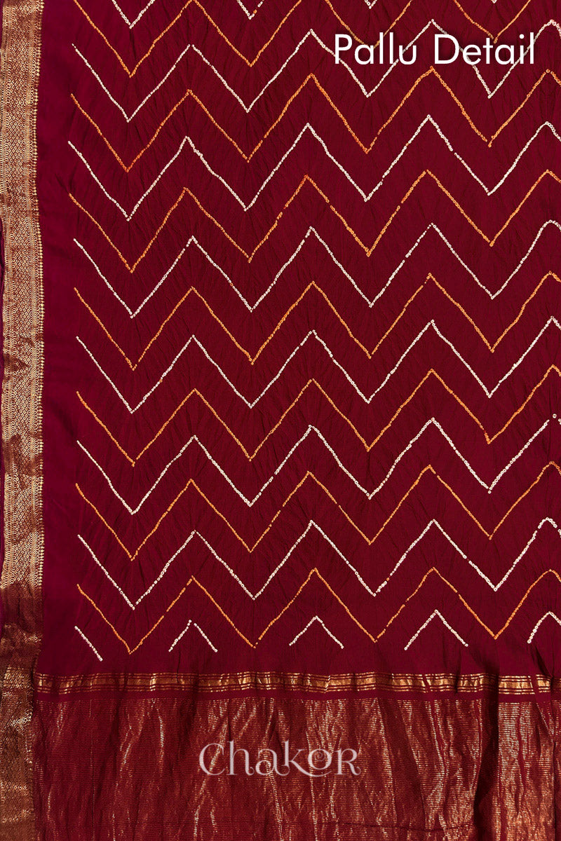 Pallu detail of Red bandhani saree with woven golden zari border and pallu.
