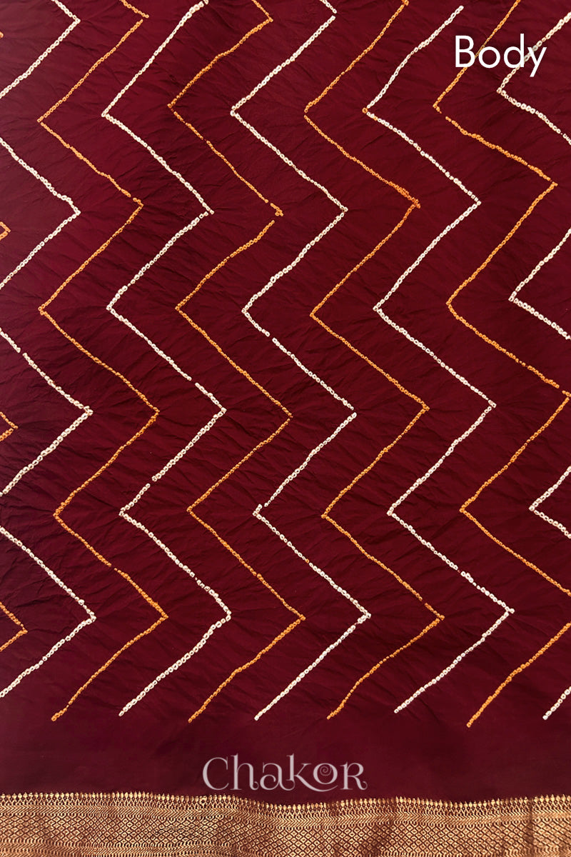 Body detail of Red bandhani saree with woven golden zari border.

