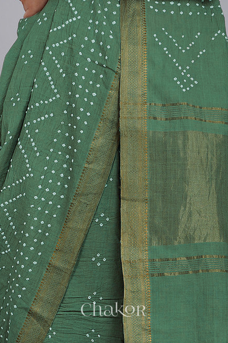 Close-up of moss green saree with rai bandhej pallu and golden border showcasing intricate tie-dye craftsmanship.
