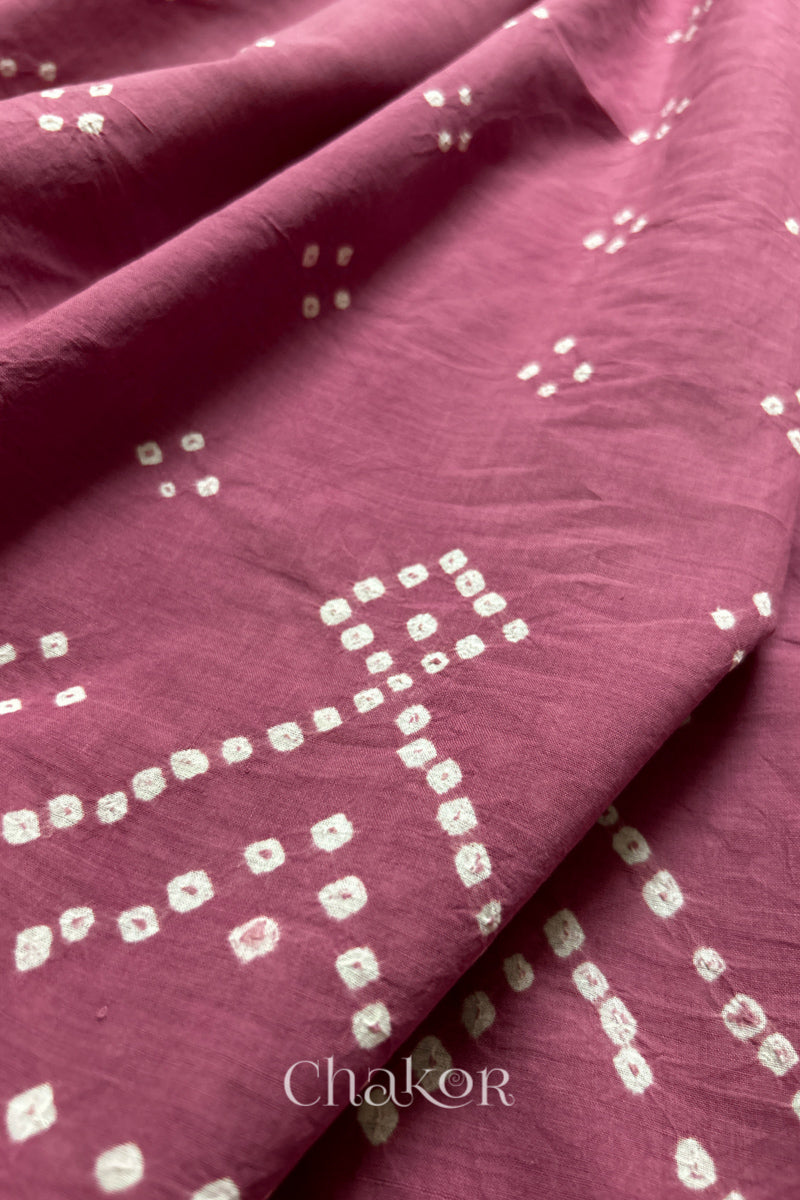 Close-up of old rose saree with rai bandhej showcasing intricate tie-dye craftsmanship and fabric texture.
