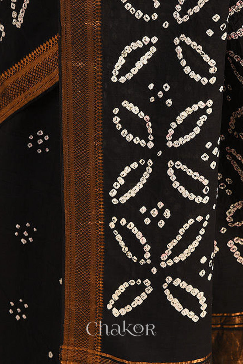 Black bandhani saree pallu with white patterns , featuring golden zari borders and 'Chakor' branding.