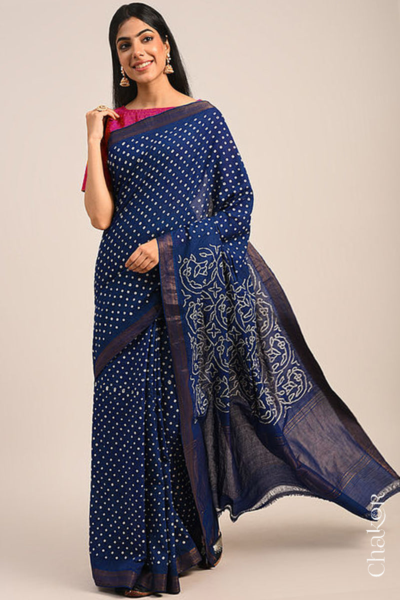 Woman wearing a navy blue bandhani saree with traditional bandhej designs and zari border pallu.