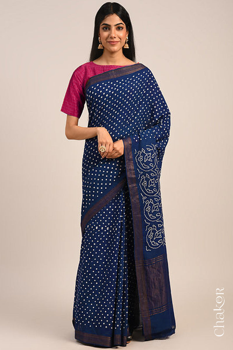Woman wearing a navy blue bandhani saree with traditional bandhej designs and zari border pallu.