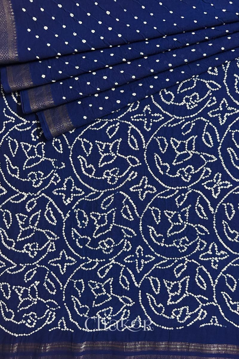 Close-up of navy blue saree, arranged in pleats with rai bandhani and dull golden border showcasing beautiful craftsmanship.
