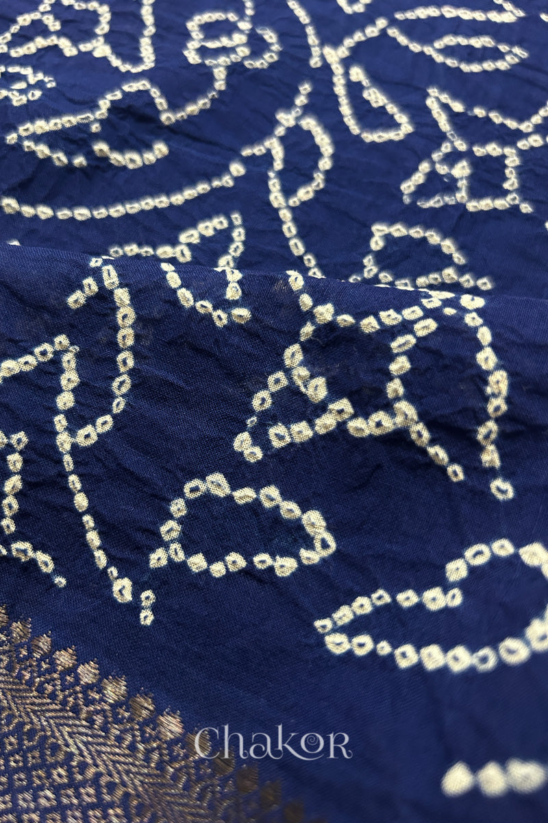 Close-up of navy blue saree with rai bandhej showcasing intricate tie-dye craftsmanship and fabric texture.
