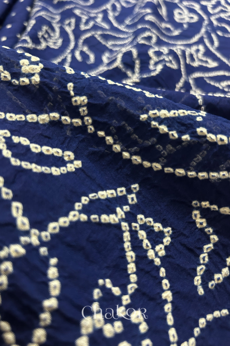 Close-up of navy blue saree with rai bandhej showcasing intricate tie-dye craftsmanship and fabric texture.
