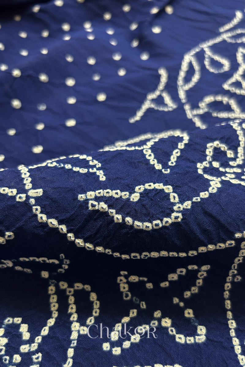 Close-up of navy blue saree with rai bandhej showcasing intricate tie-dye craftsmanship and fabric texture.

